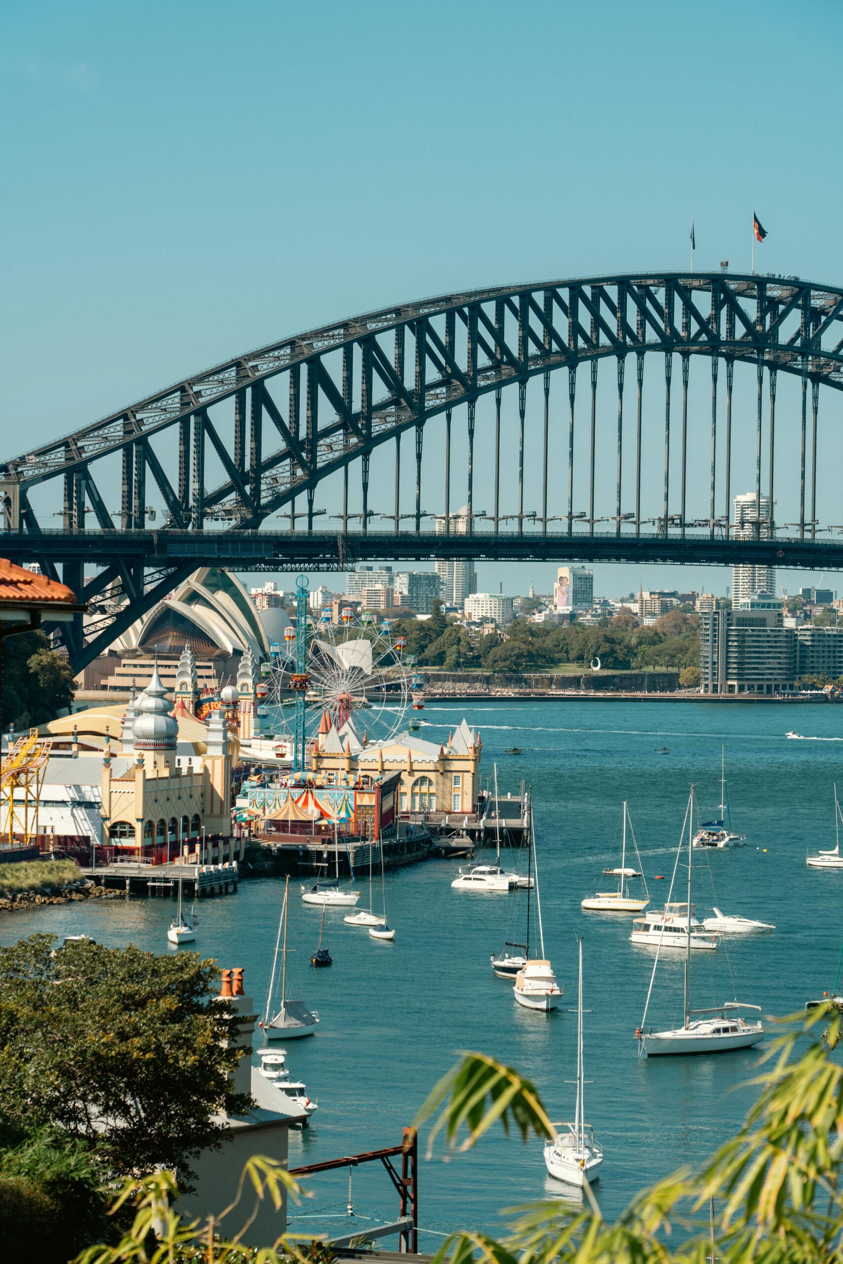 Boats and Yachts below Sydney Harbour Bridge with opera house in background